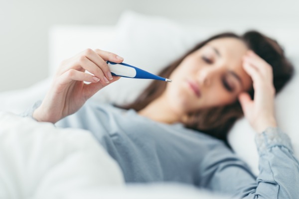 donna a letto che misura la temperatura