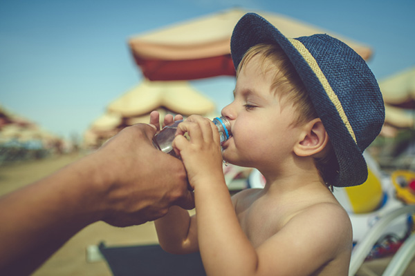 Bambino che beve acqua al mare