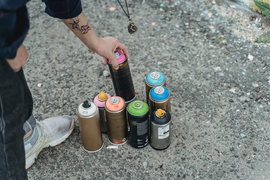A person holding their nose near a can of paint, representing the discomfort caused by the smell of paint.